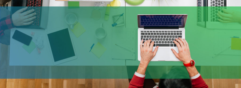 Aerial view of person typing on laptop at desk.