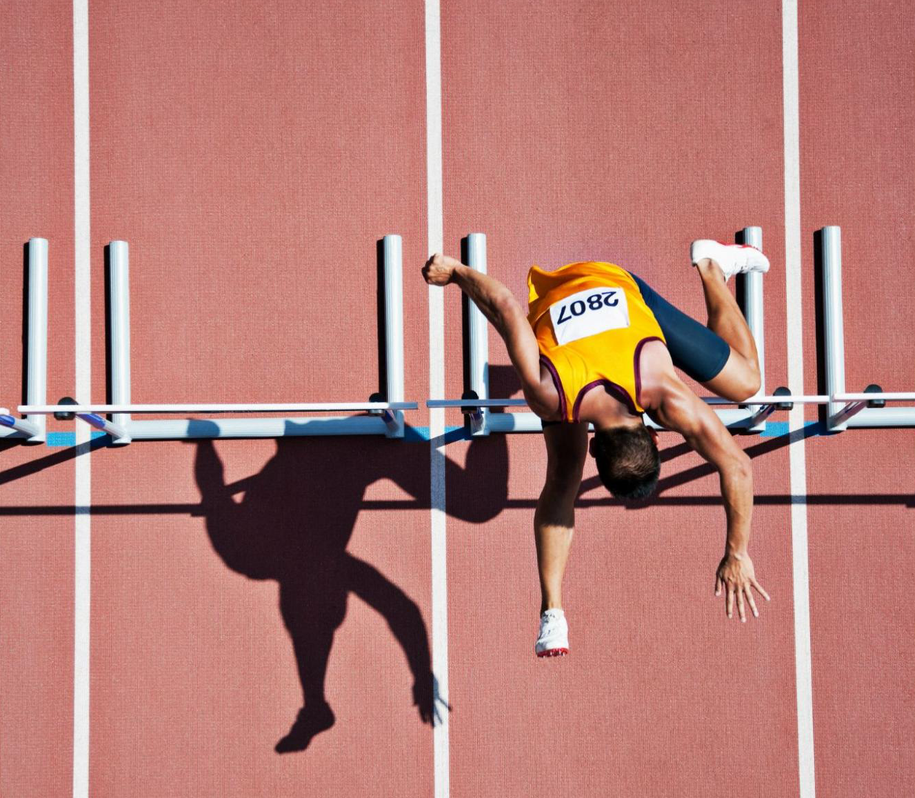 Overhead view of a running man jumping over a hurdle